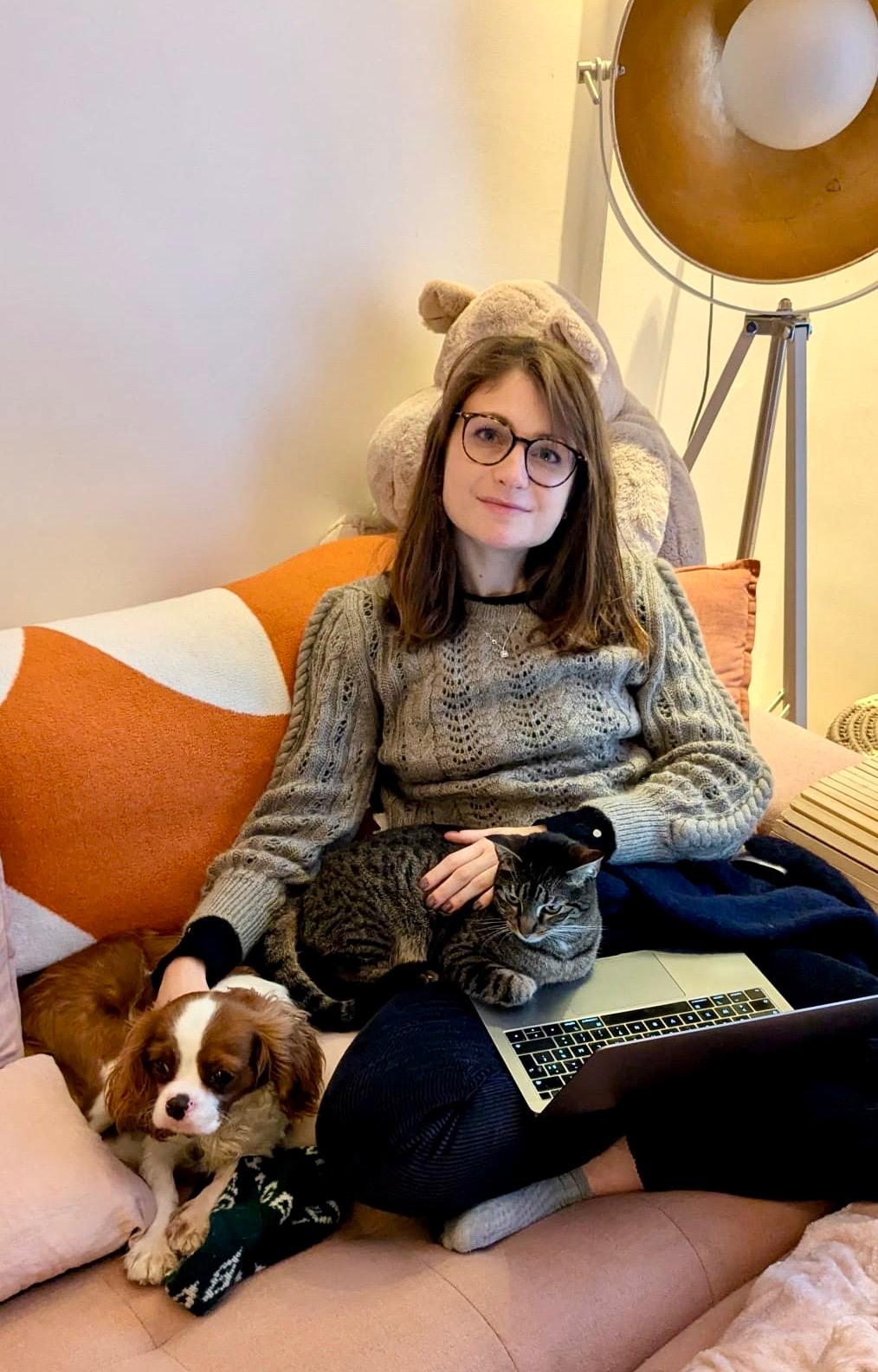 Rébecca chez elle avec Atarax la chienne et l'une des chattes sur les genoux, MacBook ouvert
